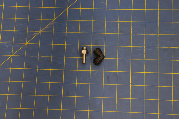 Screw type L-connector 6-1/8 INOX DUAL part on blue measuring grid mat
